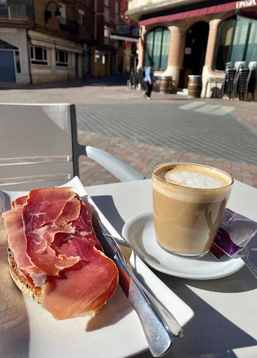 Desayuno en la terraza del Gran Plaza, se ve un café con leche y una tostada de jamón